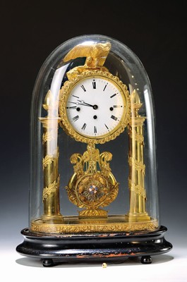 Image Table clock. so-called anniversary clock, withViennese chime, Habsburg Monarchy, around 1830/40, profiled wooden base, orig. Mineral glass dome, brass casing in portal clock shape, conical columns surrounded by leaves, eagle crown, stylized harp behind pendulum, floral bezel, enamel dial (min.dam.) massive Brass plate movement, spring limits/positions removed, lever escapement with thread suspension of the decorative pendulum, strike every quarter of at hour on a small gong with subsequent strike of the previous hour on a large gong, running time, approx /housing 2-3 , decorative