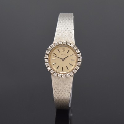 Image ROLEX 18k white gold and diamonds set ladies wristwatch, Switzerland 1960´s, manual winding, snap on case back, original gold bracelet, bezel lavish set with diamonds, silvered dial with raised hour-indices, black hands, calibre 1400, 18 jewels, diameter approx. 23 mm, length approx. 17 cm, total weight approx. 45g, glass damaged, overhaul recommended at buyer's expense, condition 2
