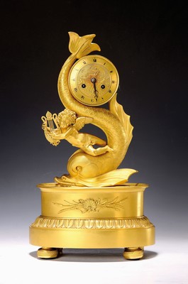 Image Pendulum with a baroque dolphin, around 1800, dial marked Delot A. Larocchelle, numbers partly blurred. Bronze case with old fire gilding, fully sculptural representation of a dolphin with putto playing Kithara on the sea, watch case rolled up in the fish's tail, center of the dial with a sea goddess, surrounding leaf frieze, key (inappropriate), pendulum movement with thread suspension of the pendulum, half-hour strike on bell, H. approx. 41cm, condition of movement 2-3 (= good condition with minor flaws), housing 2